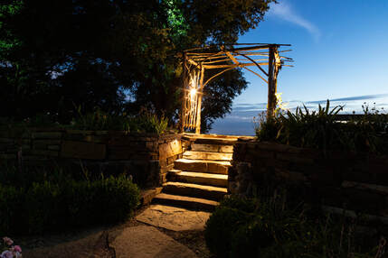 lighted stone walkway with arbor
